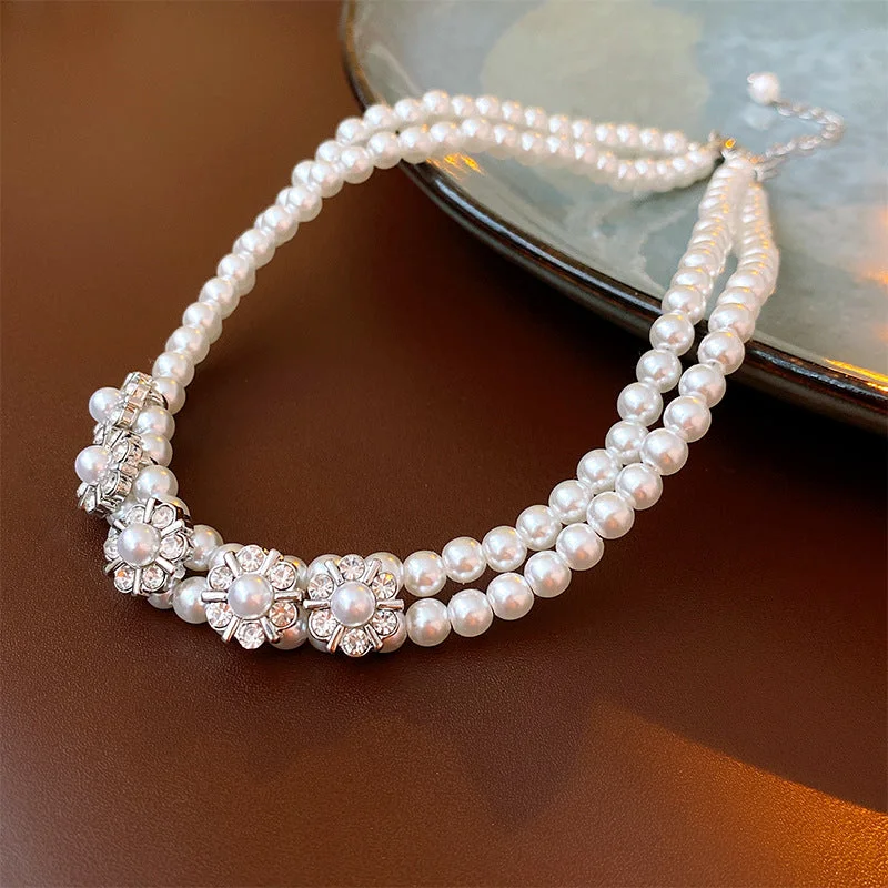 Double layered necklace adorned with diamonds pearls and flowers